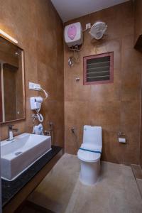 a bathroom with a white toilet and a sink at CHETTINAD HERITAGE WELLNESS RESORTS in Mithilaipatti