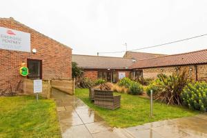 a brick building with a sign that reads emergency permission at The Gig House - relaxing countryside spa break in Pentney