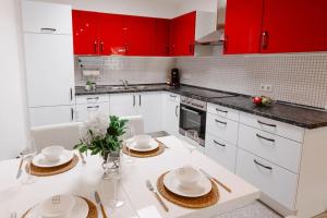 eine Küche mit roten Schränken und einer weißen Arbeitsplatte in der Unterkunft Casa Vivace in Michelstadt