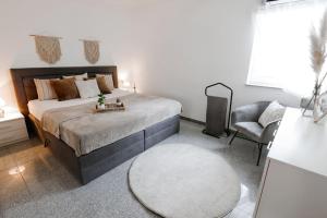 ein Schlafzimmer mit einem großen Bett und einem Stuhl in der Unterkunft Casa Vivace in Michelstadt