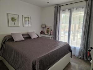 ein Schlafzimmer mit einem Bett und einem großen Fenster in der Unterkunft villa ORANANS in Marseillan