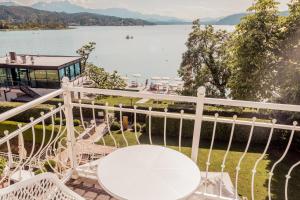 a balcony with a view of the water at Seehotel Dr. Jilly in Pörtschach am Wörthersee