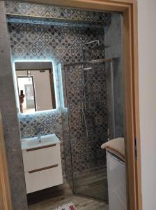 a bathroom with a sink and a mirror at Apartament Zielony in Włodawa