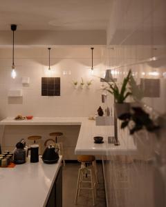 a kitchen with a white counter and stools at Guest House Ibaia Et Arramak in San Sebastián