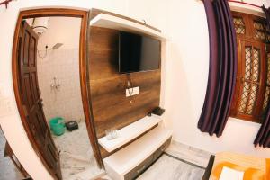 een badkamer met een wastafel en een grote spiegel bij Maa Vaibhav Laxmi Guest House in Rishīkesh