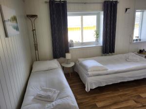 two beds in a room with a window at SAGA Overnatting in Kirkenes
