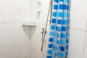 eine Dusche mit einem blauen Duschvorhang im Bad in der Unterkunft Anugrah Bromo Homestay at Desa Wisata Bromo Mitra RedDoorz in Tosari