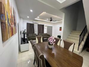 - une salle à manger et un salon avec une table et des chaises dans l'établissement RUMAH MURNI by IMPIAN HOMESTAY KLIA-SALAK TINGGI-NILAI, à Sepang