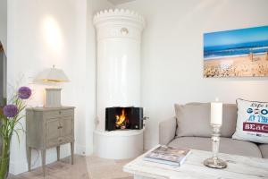 un salon avec un canapé et une cheminée dans l'établissement Strandhaus-Mylin, à Westerland