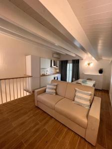 uma sala de estar com um sofá e uma cozinha em La casa di Detta (Le Scaramazze) em Pozzallo