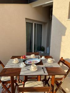 une table en bois avec des chaises et des assiettes de nourriture dans l'établissement La casa di Detta (Le Scaramazze), à Pozzallo