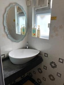 香港的住宿－芳姐可口渡假屋，浴室设有白色水槽和镜子