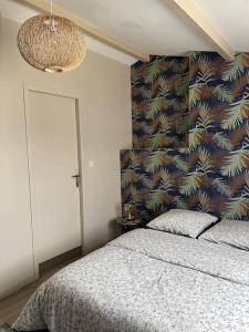a bedroom with a bed and a wall at Maison cosy avec parking gratuit in Jarnac