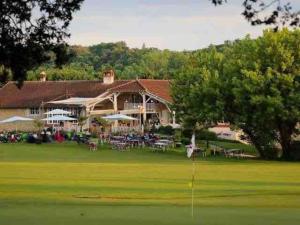 a house with a putting green in front of it at Maison cosy avec parking gratuit in Jarnac