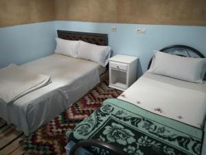 una camera con 2 letti e un tappeto di gîte d'étape ziz oasis a Achbarou
