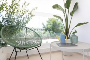 a green chair and a table in front of a window at Stellaris Apartrooms in Termoli