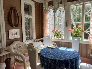 ein Esszimmer mit Tisch und Stühlen und Fenstern in der Unterkunft Bobackan pihatorpan kammarit in Alvettula