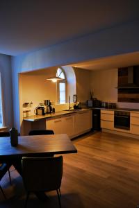 a kitchen with a wooden table and a dining room at Le Loft Pasteur in Dole +8 photos