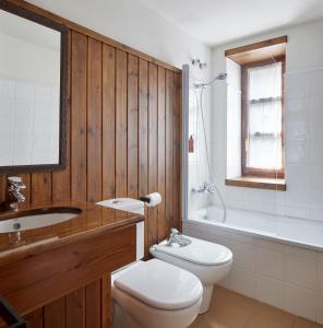 a bathroom with a toilet and a sink and a tub at Nin de Beret 2 by FeelFree Rentals in Naut Aran
