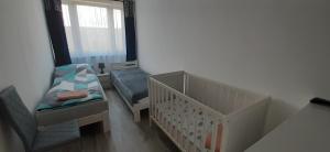 Apartament SEASIDE Gospody 5a في غدانسك: سرير طفل وكرسي في الغرفة