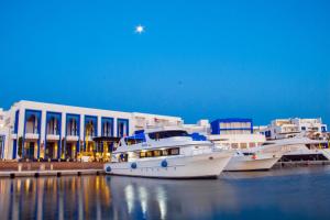 two boats are docked in a marina in front of a building at Aqaba Adventure Divers Resort & Dive Center in Aqaba
