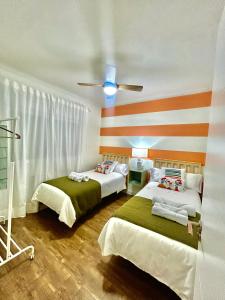 阿里納斯聖佩德羅的住宿－SolGredos，一间卧室配有两张床和吊扇