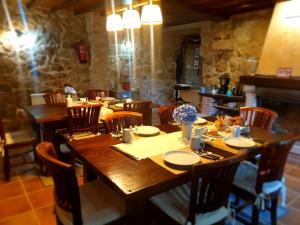 a dining room with a wooden table and chairs at Casa Rural O Bergando in Cotobade