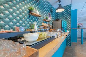 a restaurant with blue walls and a counter with food at Appart'City Confort Bordeaux Chartrons in Bordeaux