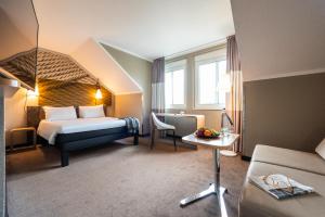 ein Hotelzimmer mit einem Bett und einem Tisch in der Unterkunft ibis Hotel Regensburg City in Regensburg