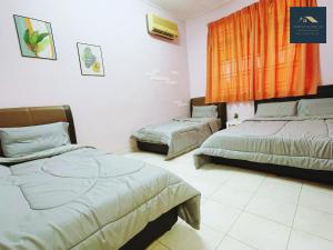 una camera con 2 letti e una tenda arancione di Sweet Home_30( 15 mins to Jonker Street ) a Malacca