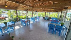 a restaurant with blue chairs and tables and windows at ÖRNEK MOTEL in Gokceada Town