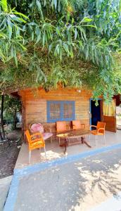 a group of chairs and a bench in front of a house at TONEDA Seaside Bungalows in Dhërmi