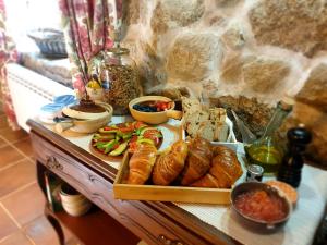 a table with a tray of bread and pastries on it at Casa Rural O Bergando in Cotobade