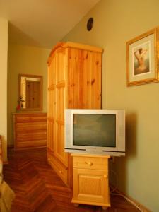 een woonkamer met een tv en een houten kast bij Hostel Del Mar in Varna