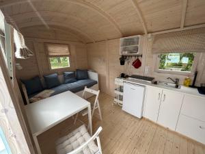 Tiny Beach House في Barkelsby: غرفة معيشة ومطبخ في منزل صغير