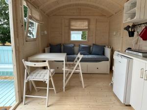 eine kleine Küche mit einem Tisch und einer Couch in einem winzigen Haus in der Unterkunft Tiny Beach House in Barkelsby