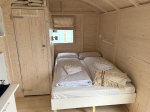 una piccola camera con due letti in una cabina di Tiny Beach House a Barkelsby