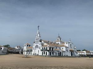 um grande edifício branco com um campanário numa praia em Apartamento Huelva Centro em Huelva
