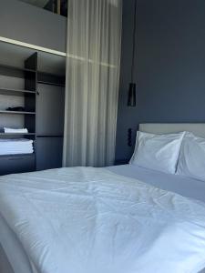 łóżko z białą pościelą i poduszkami w sypialni w obiekcie Chalet Park by Maier Höchst w mieście Höchst
