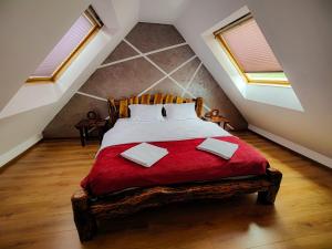 a bedroom with a large bed with a red blanket at Вила Перуле Villa Perule - Handmade cozy wooden villa in the Rhodope mountain in Shumnatitsa