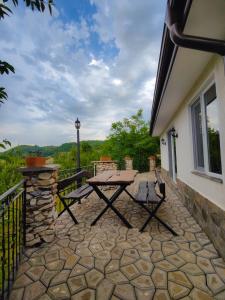 a patio with a table and chairs on a balcony at Вила Перуле Villa Perule - Handmade cozy wooden villa in the Rhodope mountain in Shumnatitsa