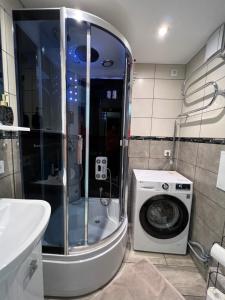 Cozy apartment في يورمالا: حمام مع غسالة ملابس وغسالة