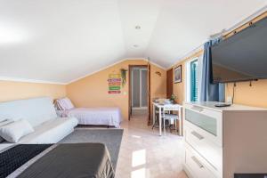 a small room with a bed and a tv at Casa de Vasco in Amora