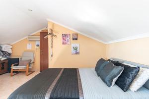 a bedroom with a bed and a chair at Casa de Vasco in Amora