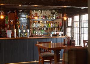 a bar with a wooden table in a restaurant at Bull Hotel by Greene King Inns in Halstead