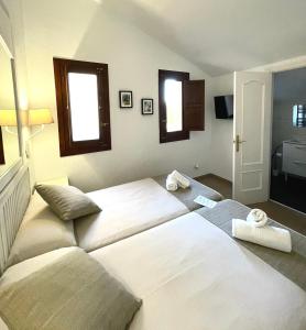 a bedroom with two beds and two windows at Miguel De Cervantes in Alcalá de Henares