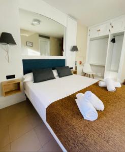 アルカラ・デ・エナレスにあるMiguel De Cervantesのベッドルーム1室(大型ベッド1台、白い枕2つ付)