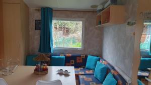 Zimmer mit Sofa, Tisch und Fenster in der Unterkunft La Maison du bonheur Mobil-home camping 3 étoiles Paris à 45 Km in Saint-Chéron