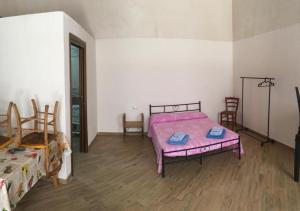 a bedroom with a pink bed and chairs in it at Residence Le Tamerici in Cariati