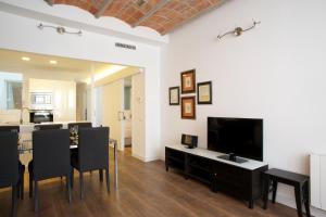 sala de estar con mesa de comedor y TV en Barcelonaforrent Tucson Suites, en Barcelona